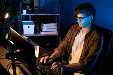 Genç işadamı, Neon Light Modern Ofis 'te yaratıcı bir başlangıç projesi için bilgisayara odaklanıyor. Düşünüyorum da, pazarlama ağı yaratıcıdan pazar kanalı tasarım konseptine çevrimiçi planlama. Toplayıcı.