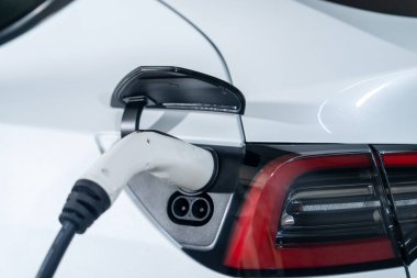 Alış veriş merkezinin otoparkında EV elektrikli araba şarjı şehir merkezindeki sürdürülebilirlik yaşam tarzını yeşil, temiz, yeniden şarj edilebilir elektrikli araç iç organları ile gösteriyor.