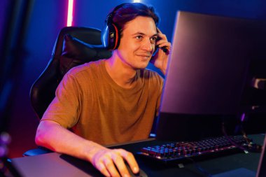 Kazanmak için çevrimiçi oyun oynayan akıllı flama makinesinin sunucu kanalı, neon ışıklı odada seçilen takım yarışması için izleyicilerle birlikte canlı yayında canlı yayında kulaklık takıyor. Bireysel.