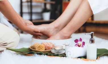 Adam lüks kaplıcalarda mutlu ayak masajına devam ederken, masör de hafif gün ışığı atmosferinde refleksoloji terapisi ya da otel ayak spa 'sında. Sessiz.