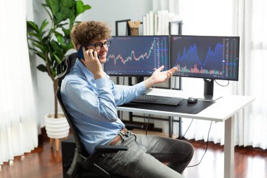 Başarılı genç yatırımcı, akıllı telefondan iş ortağına Dinamik Finansal Değişim Yatırım Dizüstü bilgisayarı ile modern ofisteki mevcut pazar grafiğinde gerçek zamanlı arıyor. Toplayıcı.