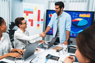 Analist ekip lideri, iş zekası ya da BI gösterge paneli ile FIntech yazılım gücünü kullanarak başarılı veri analizi toplantısından sonra iş arkadaşıyla tokalaştı. Tedbirli