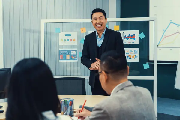 Successful businessman presenting his financial plan and data analyst with smiling face. Executive editors focus on his performance intentionally. Office Conference room meeting. Intellectual.