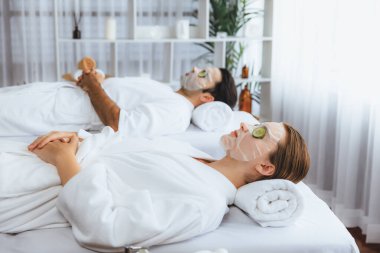 Kaplıca salonunun sakin atmosferi, birkaç müşteri lüks salatalık yüz maskesi takarak kendini yenilemeye çalışıyor. Yüz bakımı tedavisi ve güzellik konsepti. Sessiz.