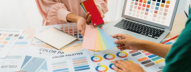 Profesyonel iç mimarların kırpılmış görüntüleri renk paletinden uygun renkler seçiyor ve ev modeli ve mimari ekipmanlar etrafa saçılıyor. - Yakın çekim. Eline odaklan. Değiştirilmiş.