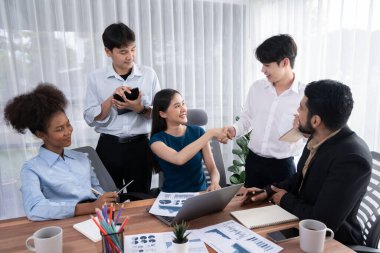 Çeşitli iş arkadaşları başarıyı şirket işyerindeki el sıkışma ve takım çalışmasıyla kutluyor. Çok kültürlü, mutlu profesyonellerden oluşan bir ekip ofiste tokalaşarak birlik oldular. Uyum