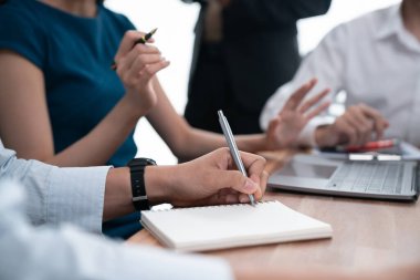 Sekreter, toplantı odasında görüşen bir grup çok ırklı iş adamıyla şirket toplantısında defterine not alıyor. Modern ofiste profesyonel toplantılarda çeşitlilik. Uyum