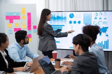 Genç Asyalı iş kadını modern toplantıda TV ekranında veri analizi paneli sunuyor. Bir grup iş adamıyla konferans odasında iş sunumu. Uyum