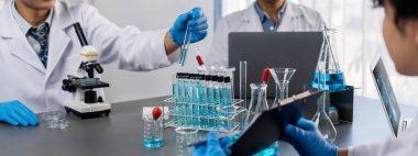 Kendini adamış bir grup bilim adamı tıbbi laboratuvarda kimyasal deneyler ve araştırmalar yaparak yeni aşı ilacı veya antibiyotik için çığır açan gelişmeler gerçekleştiriyor ve laptopta test sonuçları üzerinde çalışıyorlar. Neoterik