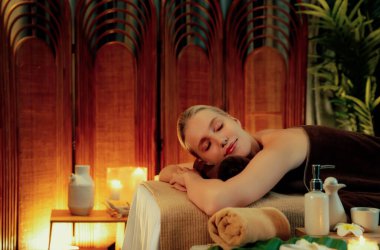 Beyaz kadın müşteri stres önleyici spa masajının keyfini çıkarıyor ve lüks otel ya da otelde sıcak mum ışığında güzellik teniyle eğleniyor. Sessiz.