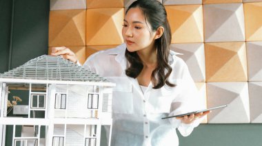 Tablet kontrol evi modelini kullanan güzel bir proje yöneticisi. Mimar mühendisinin portresi tabletteki veri analizini kullanarak bina inşaatını denetliyor. İş inşaat konsepti. Yönlendirici.