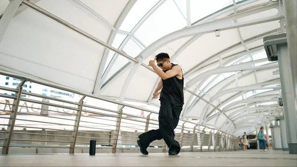 細工されたハンサムなヒップスターは狭い廊下でストリートダンスを行います プロのヒップホップダンサーがスタイリッシュな服を着ている間 都市の廊下でBボーイステップを示しています アウトドアスポーツ 2024 スプライトリー — ストック写真