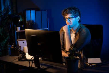 Genç işadamı, Neon Light Modern Ofis 'te yaratıcı bir başlangıç projesi için bilgisayara odaklanıyor. Düşünüyorum da, pazarlama ağı yaratıcıdan pazar kanalı tasarım konseptine çevrimiçi planlama. Toplayıcı.