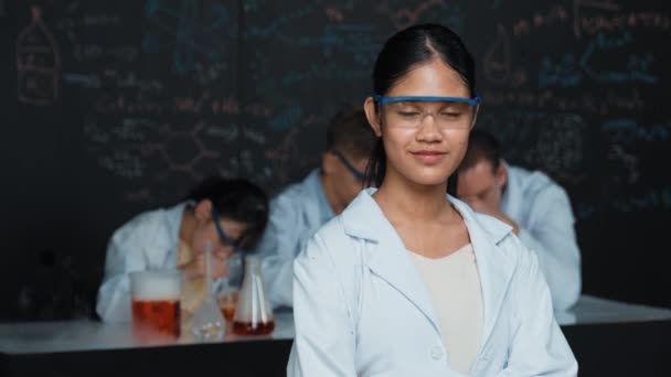 Dívka Dívá Kameru Založenou Rukou Zatímco Lidé Dělají Experimenty Laboratoři — Stock video
