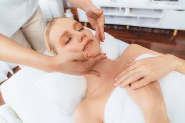 Kafkasyalı kadın stres önleyici kafa masajından ve lüks tatil beldesi ya da otel spa salonundaki modern ışık ortamında yüz güzelliği eğlencelerini şımartmaktan hoşlanıyor. Sessiz.