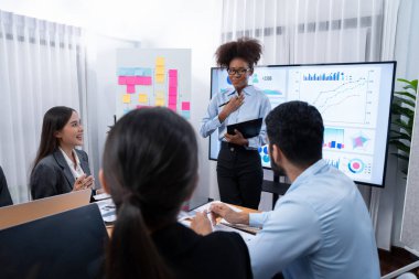 Genç Afrikalı iş kadını modern toplantıda TV ekranında veri analizi paneli sunuyor. Bir grup iş adamıyla konferans odasında iş sunumu. Uyum