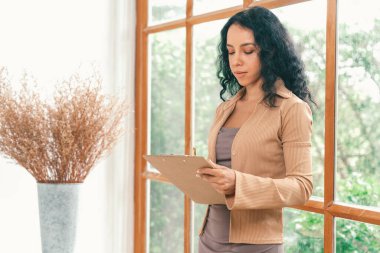 Klinikteki psikolog kadın. Profesyonel portresi. Dostane gülümsemesiyle hastayı psikoloğa davet ediyor. Deneyimli ve kendinden emin psikolog çok önemli bir uzmandır.