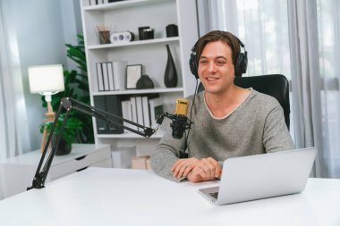 Sunucu kanalı, gülümseyen akıllı yayıncı kaydı, senaryosu ve akıllı telefonuyla sosyal medyada sohbet programı, kulaklık takarak modern ev stüdyosundaki video flamalarını kaydediyor. Bireysel.