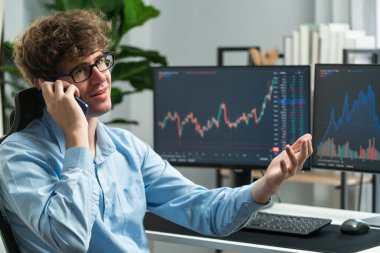 Modern ofiste mevcut pazar grafiğinde dinamik döviz geçmişi olan akıllı telefondan komisyoncuya doğru tartışan genç bir borsa yatırımcısı karmaşık verileri açıklıyor. Toplayıcı.