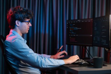 Uygulama pc ekranları ile çevrili çevrimiçi yazılım geliştirme bilgilerini yoğunlaştıran IT geliştiricisi, neon modern ofis evindeki web sitesinde yazılım için program yaratıyor. Toplayıcı.