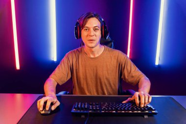 Kazanmak için çevrimiçi oyun oynayan akıllı flama makinesinin sunucu kanalı, neon ışıklı odada seçilen takım yarışması için izleyicilerle birlikte canlı yayında canlı yayında kulaklık takıyor. Bireysel.