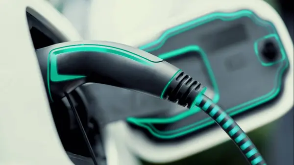 Closeup EV charger plugged into electric car for electric recharging from electric charging station with glowing light cable. Cutting-Edge innovation and future green energy sustainability. Peruse