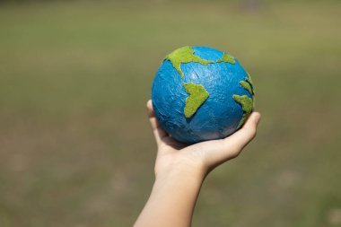 Dünya gezegenini ESG ilkesi ve çevre dostu enerjisiyle daha parlak bir gelecek için Dünya günü olarak el ele tutuşan genç çocuklar. Döngü