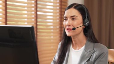 Kadın çağrı merkezi operatörü ya da müşteri hizmetleri çalışanı, müşteriye yardım etmek için kulaklıkla konuşurken çalışma alanı üzerinde çalışıyor. Profesyonel modern iş hizmeti. Blithe