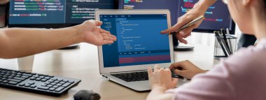 Bilgisayar ekranında program kodu gösterilirken iki akıllı kooperatif bilgisayar mühendisi program kodunu çözmek için takım çalışması yapıyor. Laptop, web geliştirme, programcı, Java betiği. Filizlenen.