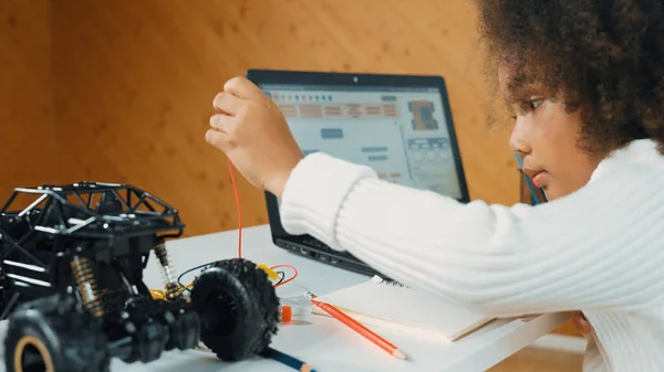 スマートアフリカの女の子は ラップトップ設定やプロンプトコードを書いている間 ワイヤーを使用しながらロボット車を構築します Stem技術オンライン教室でコンピュータに取り組む熟練した女性学生 エラー — ストック写真