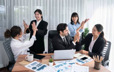 Bir grup mutlu iş adamı beşlik bir jest ve başarılı bir takım çalışması yapıyor. Çeşitli yarış bürosu çalışanları şirket ofisinde pazarlama planlamasında ilerleme kaydettikten sonra kutlama yapıyorlar. Habiliment