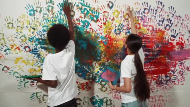 Back View Young Diverse Children Paint Colorful Stained Wall Hand — Stock Video