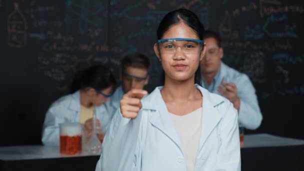 High School Flicka Tittar Kameran Medan Människor Gör Experiment Laboratoriet — Stockvideo