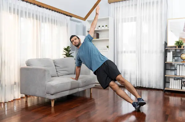 Athletic body and active sporty man using furniture for effective targeting muscle gain exercise at gaiety home exercise as concept of healthy fit body home workout lifestyle.