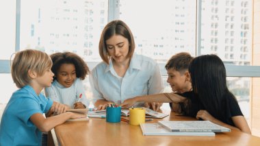Çizim kitabında işaret kullanarak çeşitli öğrencilerin ve zeki öğretmen çizimleri ve boyamaları mutlu olsun. Çok kültürlü, zeki bir öğrenci yetenekli beyaz bir eğitmenle konuşurken çizim kitabı kullanıyor. Etkinlik.