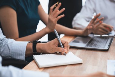 Sekreter, toplantı odasında görüşen bir grup çok ırklı iş adamıyla şirket toplantısında defterine not alıyor. Modern ofiste profesyonel toplantılarda çeşitlilik. Uyum