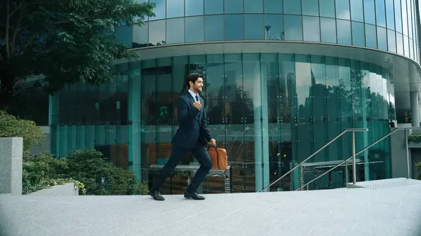 Skilled business man wearing formal suit while standing in urban city. Professional project manager standing in front of building while wearing formal suit. Office man finding for new job. Exultant.