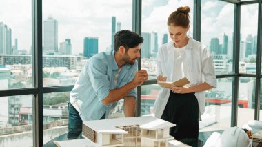 Yetenekli mimar mühendis takımı ev modeli inşaatı hakkında konuşuyor. Akıllı iç mimar paylaşımı, güzel bir iş arkadaşı not alırken bina tasarımından bahsetmek. Tasarım. İzleme