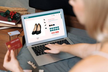 Genç bir kadın internet bankacılığı için kredi kartıyla dizüstü bilgisayar kullanıyor. Evinde online ödeme kapısı ile E ticareti yapıyor. Banka kartıyla modern ve kullanışlı online alışveriş. Blithe