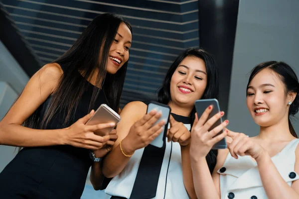 3人の女性の友人が携帯電話を見ながら会話をしている ソーシャルメディア ゴシップニュース オンラインショッピングのコンセプト インタビュー — ストック写真