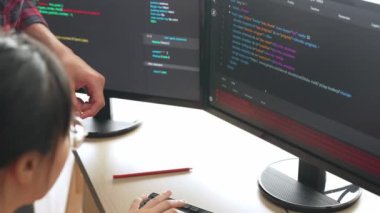 Yavaş çekimde geri uç veya yazılım geliştirici yöneticisi ekibini monitörde hata ayıklama ve karmaşık kod algoritmalarını çözmede yeni uygulama programı geliştirmede denetliyor. Filizlenen