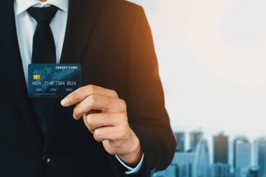 Bir kredi kartı tutan işadamının portresi kameraya ön görüntüyü yakından gösteriyor. Çevrimiçi alışveriş işi ve nakit ödeme konsepti. uds