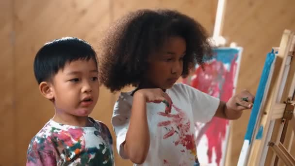Счастливая Творческая Африканская Девушка Нарисовала Нарисовала Холст Вместе Азиатским Мальчиком — стоковое видео