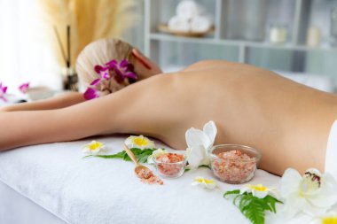 Lüks spa salonlarında sıcak mum ışığında cilt bakımı yaptıran kadın müşteri. Sağlık Spa vücut fırçasında tuz temizleme güzellik tedavisi. Sessiz.