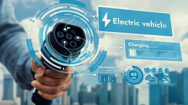Kameranın önüne odaklanmış EV şarj cihazı bulanık şehir manzaralı akıllı dijital batarya durum hologramını gösterir. Alternatif temiz enerji kullanan EV araba şarjı CO2 salınımını azaltıyor. İnceleyin