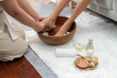 Kadınlar lüks spa salonlarında keyifli ayak masajlarına devam ederken, masör de hafif gün ışığı atmosferinde refleksoloji terapisi veya otel ayak spa 'sında. Sessiz.