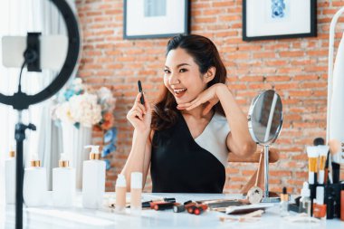 Asyalı Kadın Etkilenen Vlog 'ta canlı yayın yapan videolar sosyal medya ya da blog' un çoğunu oluşturuyor. Kozmetik stüdyosu ışıklandırmalı mutlu genç kız çevrimiçi pazarlama oturumu yayını için.