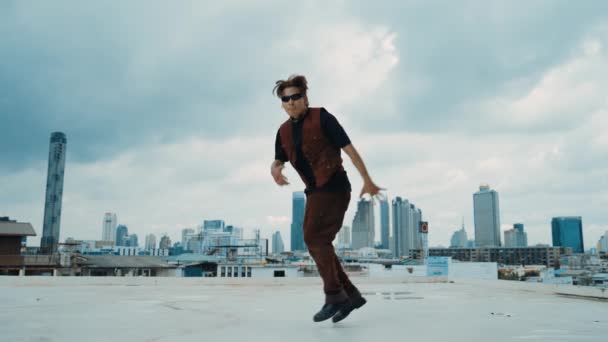Boy舞蹈表演由专业街头舞者在屋顶上与天空碎屑 城市景观 迷人的亚洲嬉皮士表演 迈着充满活力的步伐 2024年户外运动 Hip Hop风格 Hiphop — 图库视频影像