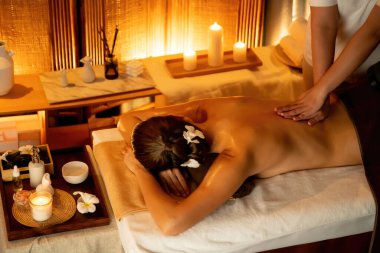 Beyaz kadın müşteri stres önleyici spa masajının keyfini çıkarıyor ve lüks otel ya da otelde sıcak mum ışığında güzellik teniyle eğleniyor. Sessiz.