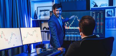 İki borsa simsarı, Panorama 'da gece gözlemde dinamik değerli yatırım oranını tartışıyor. Borsadaki işadamı işyerinde neon ışıkta ekonomiyi sunuyor. Satılabilir.